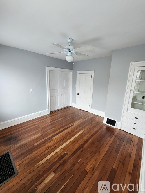 A room with wooden floors and a ceiling fan.