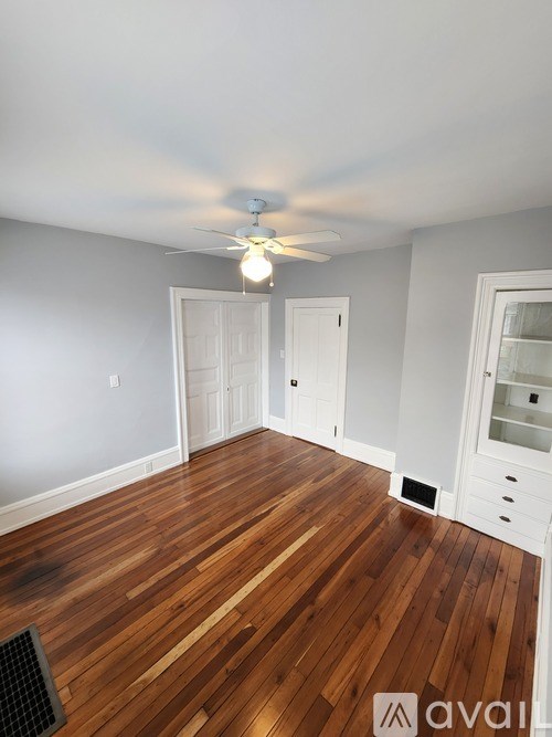 A room with wooden floors and a ceiling fan.