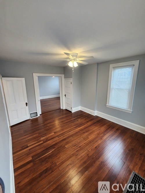 A room with wooden floors and a ceiling fan.