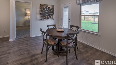 A dining room with a round table and chairs.