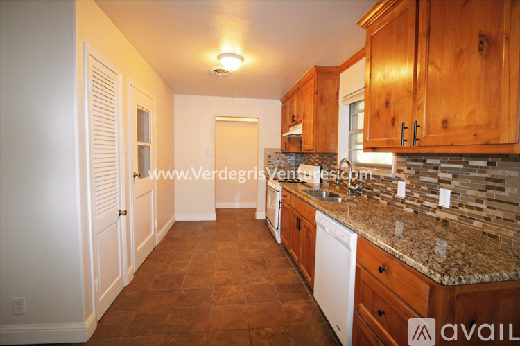 A kitchen with wooden cabinets and a granite countertop.