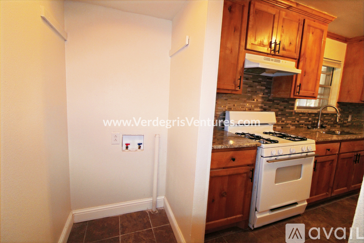 A kitchen with wooden cabinets and a white stove.