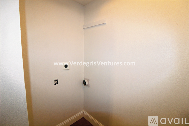 A room with a white wall and a black electrical outlet.