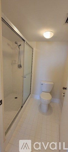 A white toilet in a bathroom with a glass shower door.