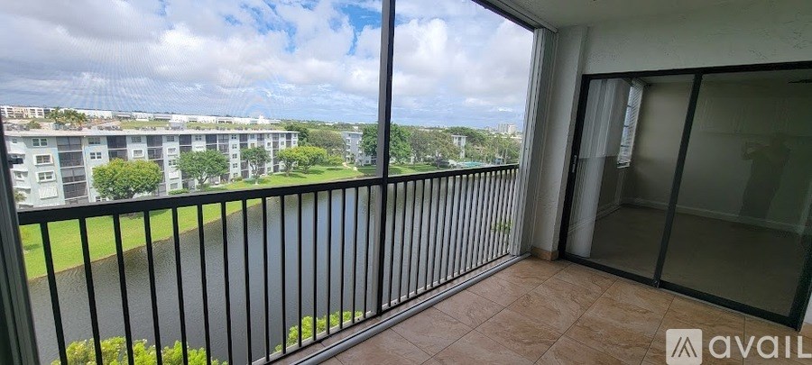 A balcony with a view of apartment buildings and trees.