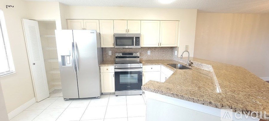 A kitchen with a granite counter top and stainless steel appliances.