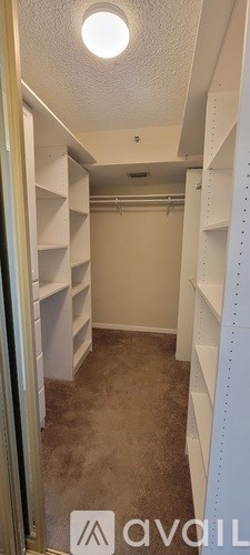 A small, empty room with white shelving units and a carpeted floor.