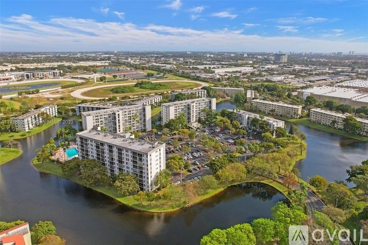 A bird's eye view of a city with a large body of water in the foreground and buildings in the background.