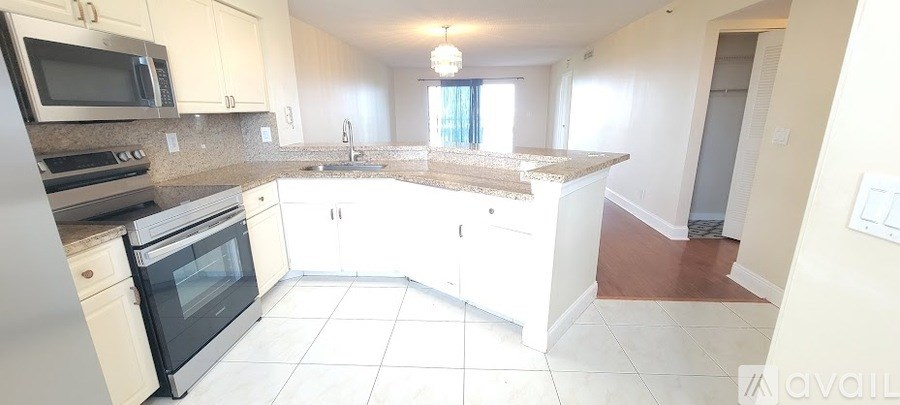 A kitchen with white cabinets and a granite countertop.