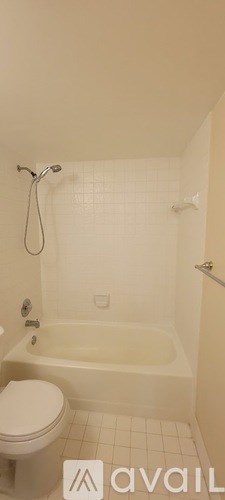A white bathroom with a tub, toilet and shower.