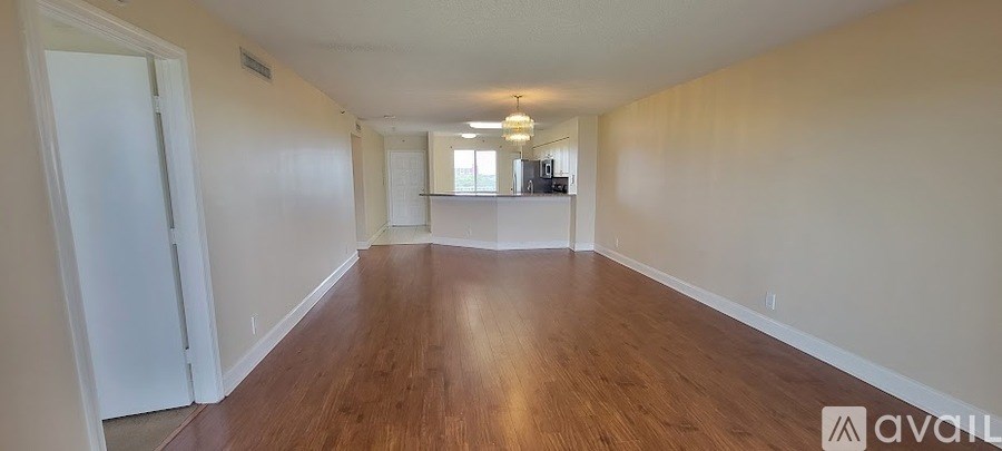 A long hallway with wood floors and white walls.