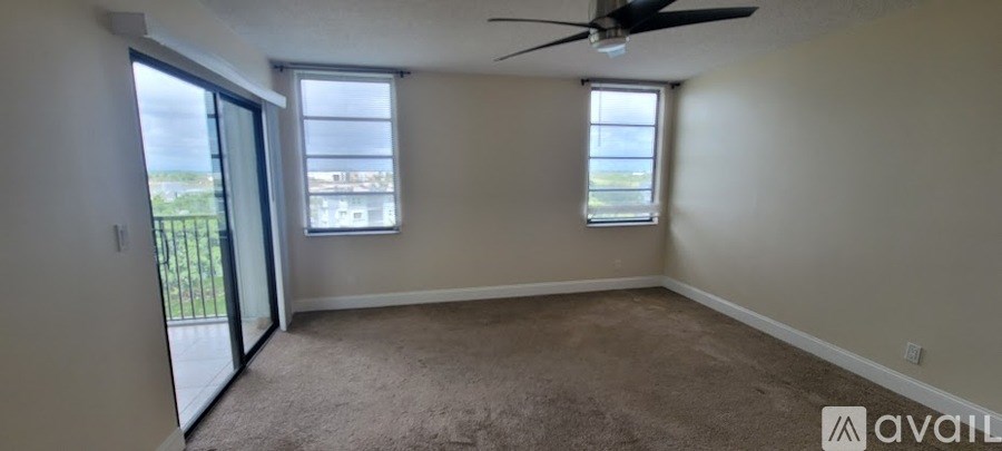A room with a fan and two windows is available for rent.