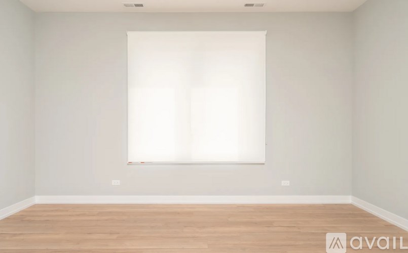 A room with a large window and wooden flooring.