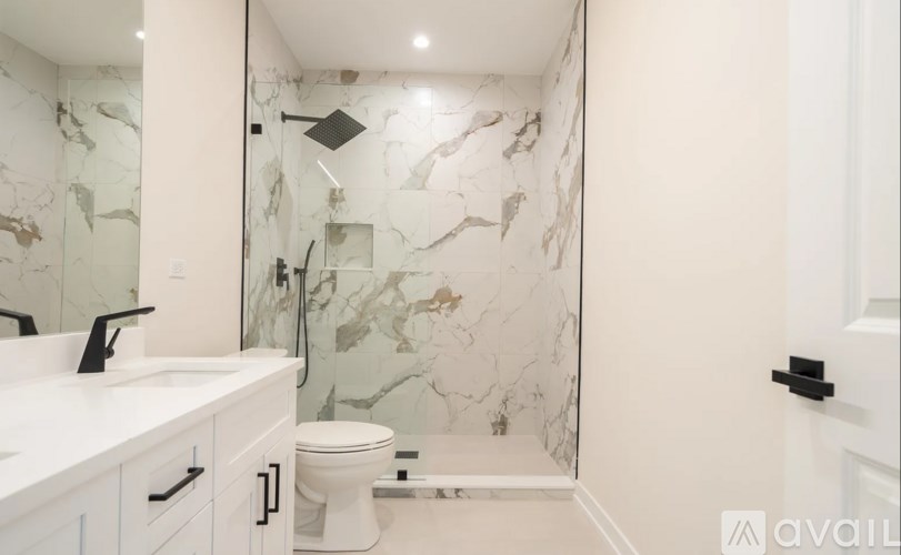 A bathroom with a marble wallpaper and a white toilet.