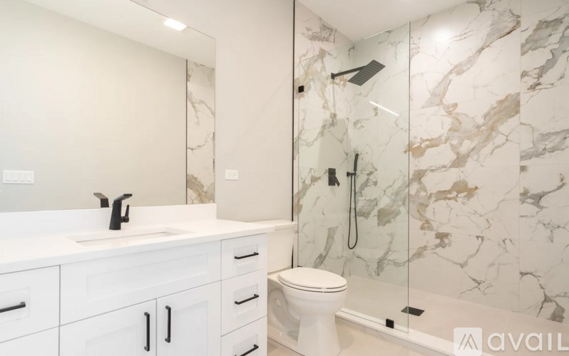 A bathroom with a marble wall and a white toilet.