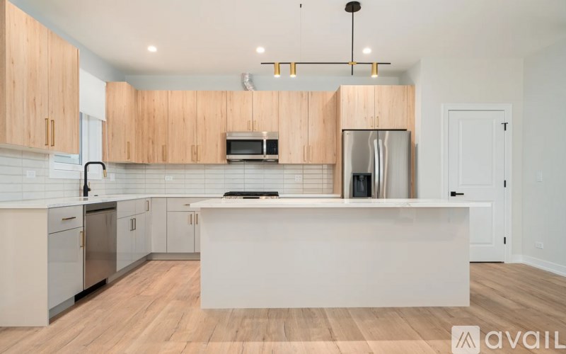 A kitchen with wooden cabinets and a white island.
