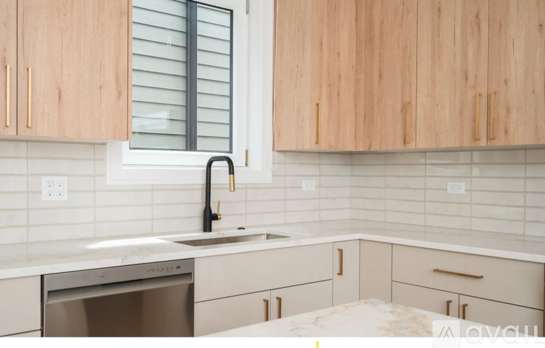A kitchen with wooden cabinets and a stainless steel dishwasher.