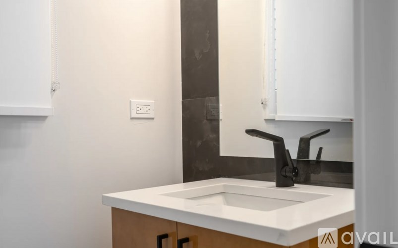 A modern bathroom with a white sink and a brown counter.