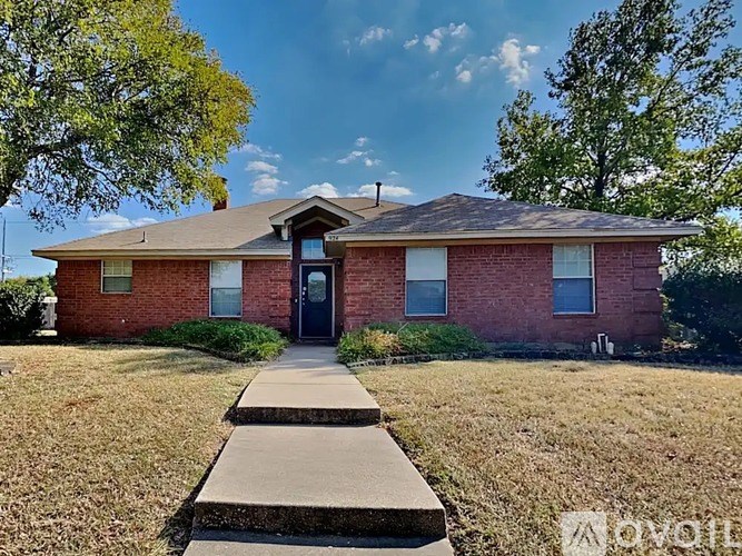 A red brick house with a black door and a small porch.