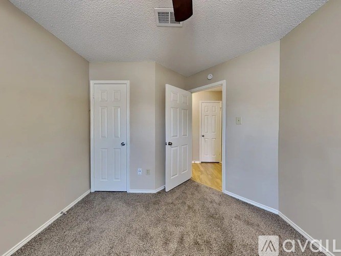 A room with two white doors and a carpeted floor.