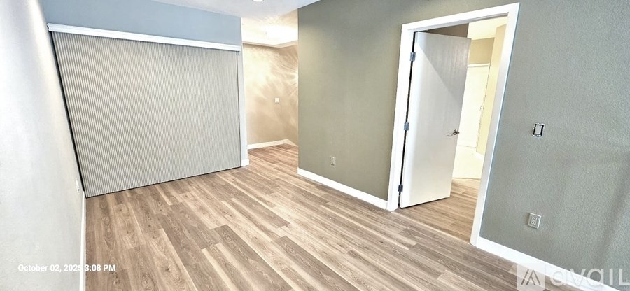 A room with a wooden floor and a white door.