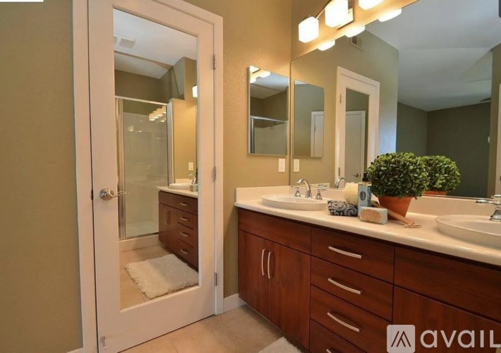 A bathroom with a double sink vanity and a large mirror above it.