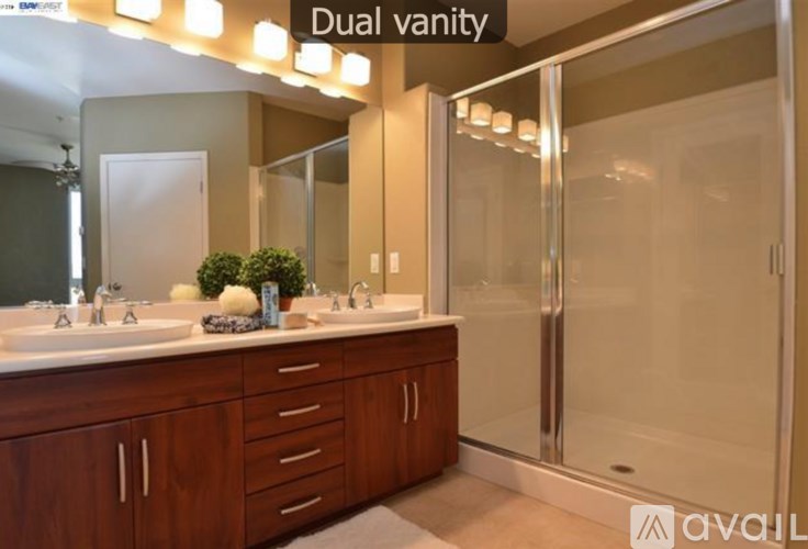 A bathroom with dual vanity sinks and a walk-in shower.