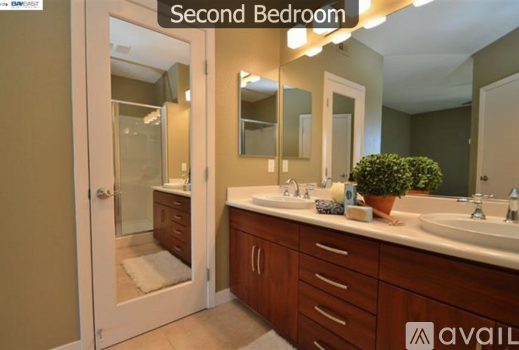 A bathroom with a double sink and a mirror above it.