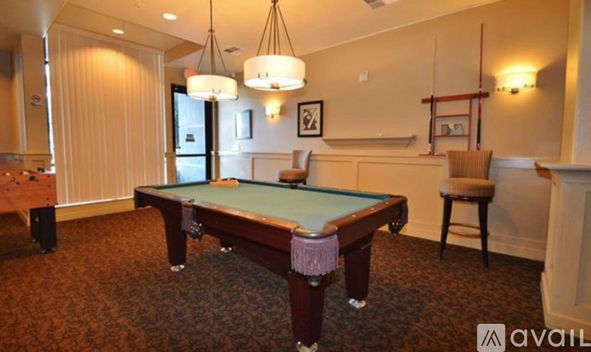 A pool table in a room with a chair and a fireplace.
