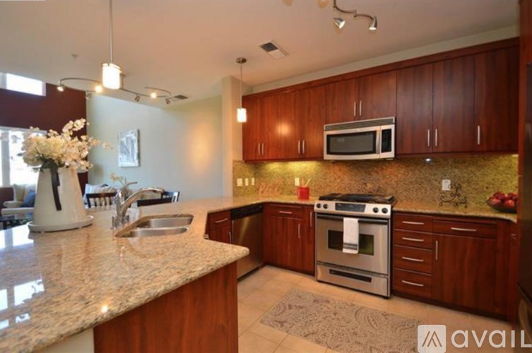 A kitchen with a granite countertop and a stainless steel oven.