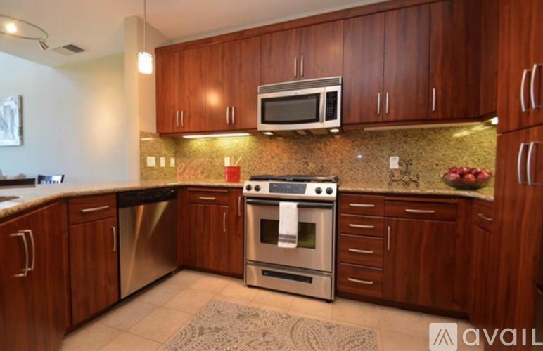 A kitchen with wooden cabinets and a stainless steel oven.