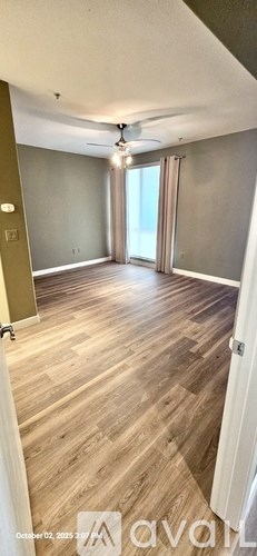 A room with wooden flooring and a ceiling fan.