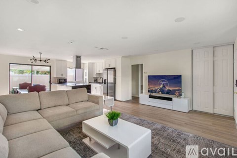 A modern living room with a large sectional sofa and a flat-screen TV.