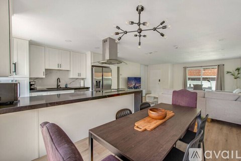 A modern kitchen with a dining table and chairs.