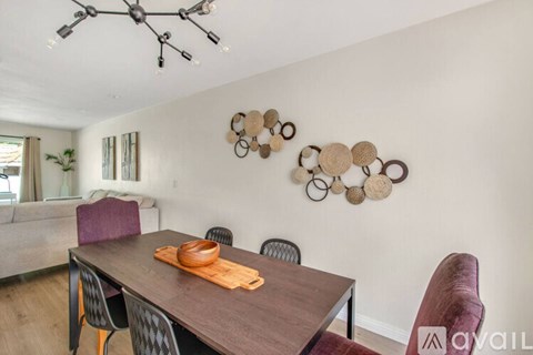 A dining room with a wooden table and chairs.