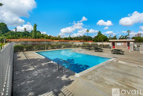 A pool surrounded by a fence with a mountain in the background.