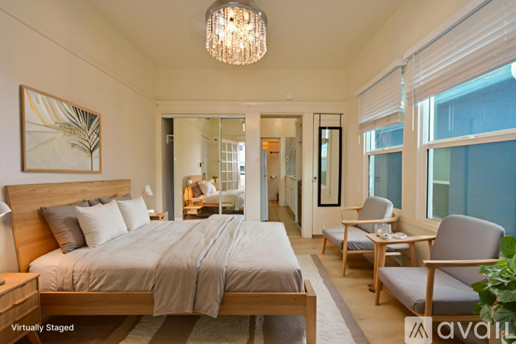 A room with wooden floors and white walls, with a sliding glass door leading to a balcony.