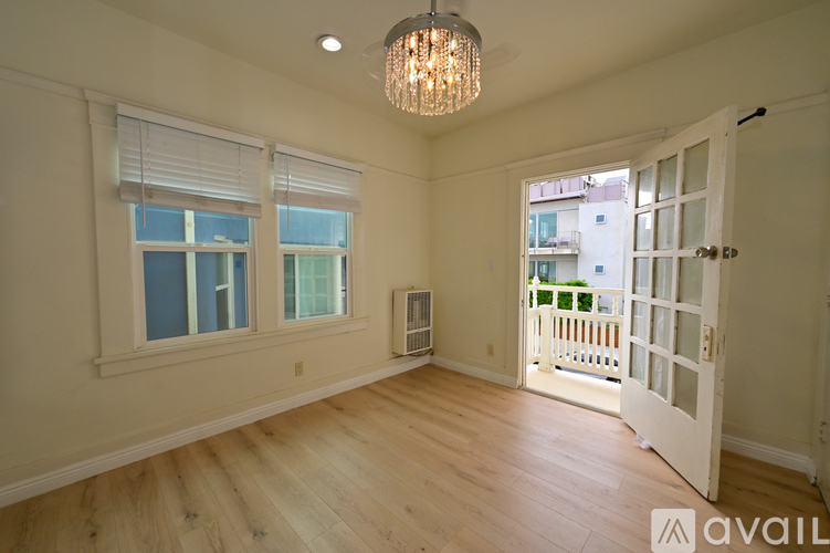A white kitchen with a gas stove and a window.