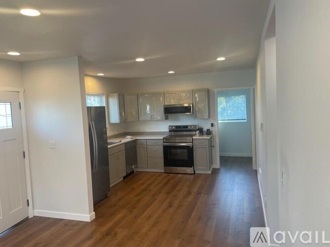 A kitchen with a refrigerator, oven, and cabinets.