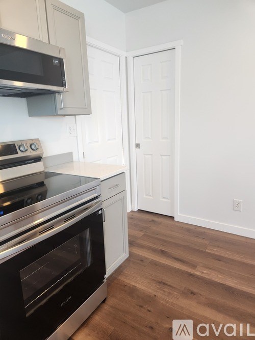 A kitchen with a black oven and white cabinets.
