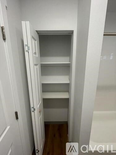 A white door with a shelf inside is open.