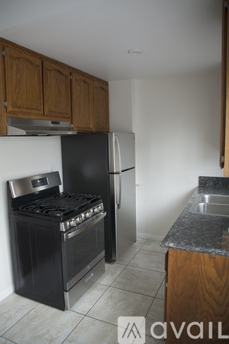 A kitchen with a black stove top oven and a black refrigerator.