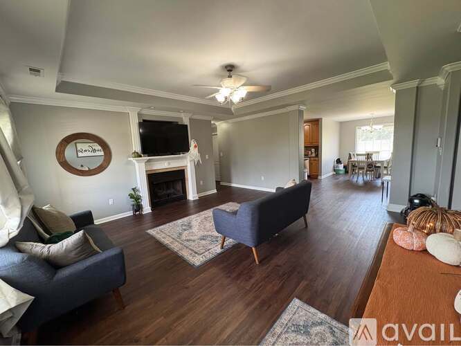 A living room with a dark blue couch and a television mounted above the fireplace.