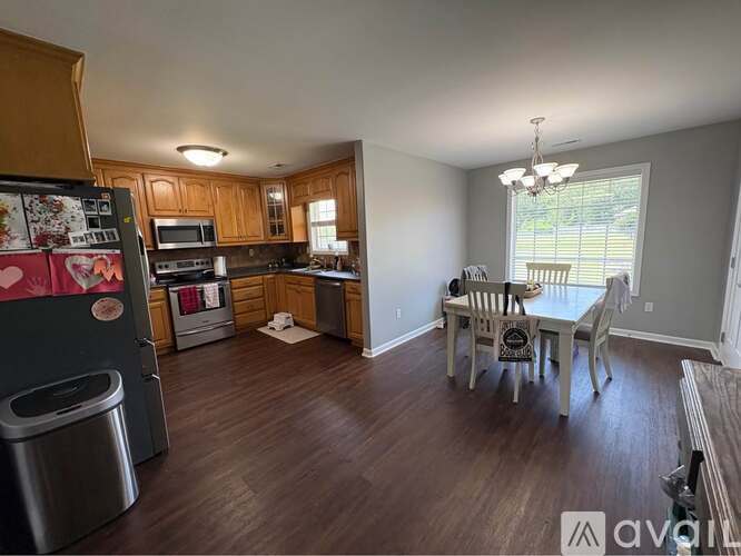 A kitchen with wooden cabinets and a dining table with chairs.