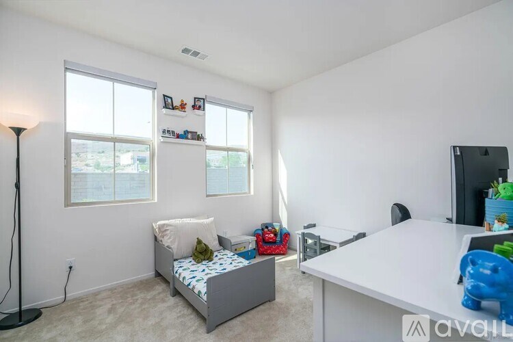 A bedroom with a bed, desk, and window.