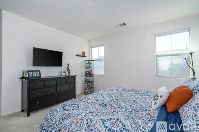 A bedroom with a bed, dresser, and television.