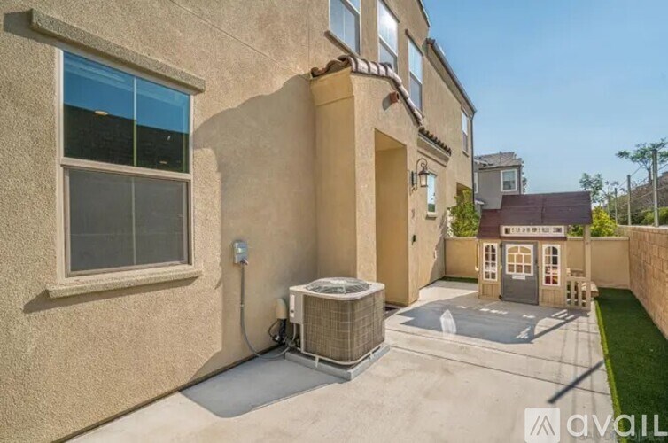 A house with a beige wall and a window is for sale.