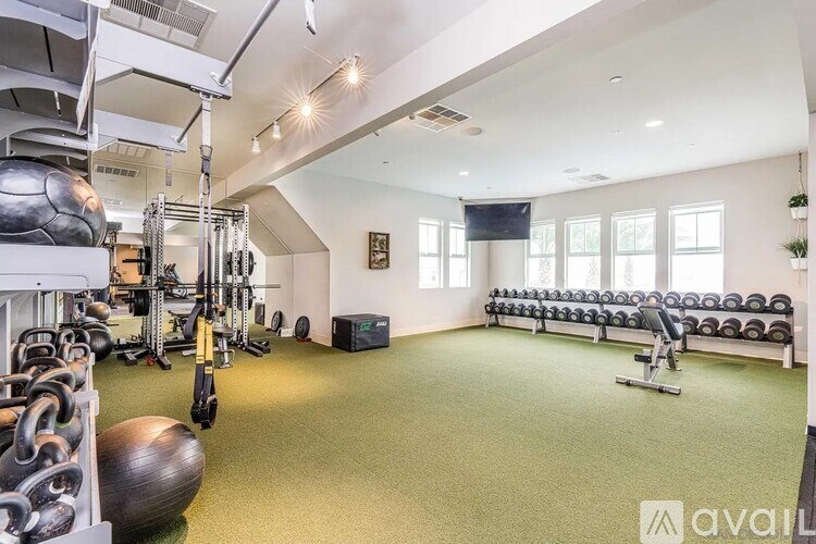 A gym with a variety of equipment including weights and exercise machines.