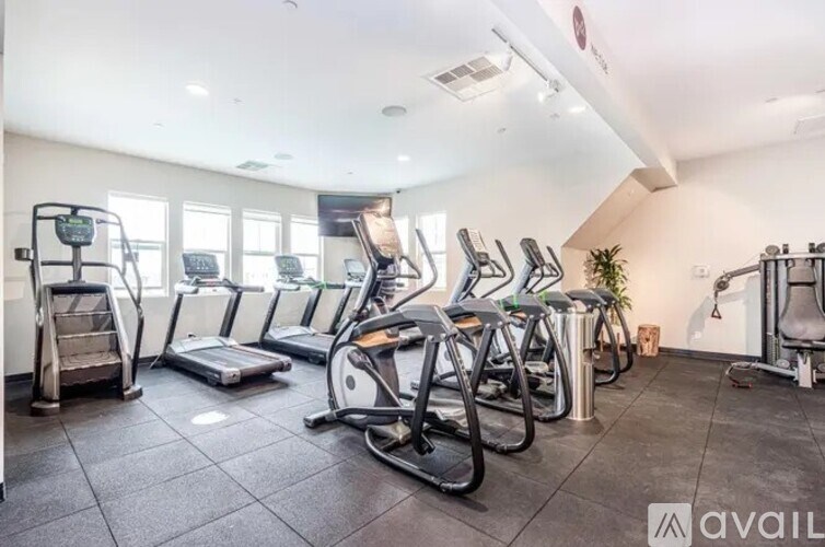 A gym with treadmills, elliptical machines, and other exercise equipment.