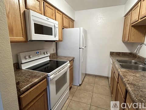 A kitchen with a white refrigerator, white oven, white microwave, and white stove.